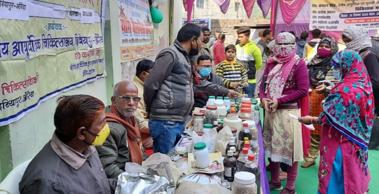 स्वास्थ्य शिविर में औषधियां वितरित करते कर्मचारी